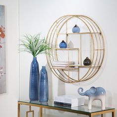 a table with two blue vases on top of it and a gold circular shelf