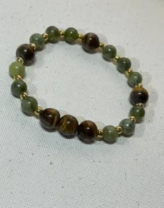 This beautiful handmade bracelet was made with Green aventurine tiger eye quartz beads.  It's the perfect accessory for any occasion whether casual or elegant  Measure are : 6mm  Fits most wrist sizes and has some gentle flexible give to put on and take off easily. Green Aesthetic Bracelets, Green And Brown Bracelets, Brown Beads Bracelet, Brown Bracelet Ideas, Green Beaded Bracelets, Brown Bracelet, Hazel Eyes, Quartz Beads, Eye Bracelet