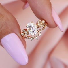 a woman's hand with pink manicured nails and a ring on her finger