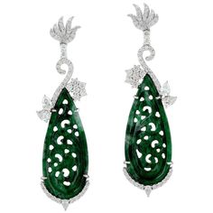 These stunning hand carved Jade earrings are crafted in 18-karat white gold. It is set in 18.5 carats Jade and 1.9 carats of sparkling diamonds. FOLLOW MEGHNA JEWELS storefront to view the latest collection & exclusive pieces. Meghna Jewels is proudly rated as a Top Seller on 1stDibs with 5 star customer reviews. All items manufactured by us are handmade and can be customized or redesigned. Composition Size-57X16 MM Total Weight-14.746 Gold Weight(Gms)-10.666 Diamond Wt(Cts)-1.9 Jade Wt(Cts)-18. Luxury Platinum Diamond Earrings Hallmarked, Luxury Carved Earrings For Formal Occasions, Luxury Carved Earrings, Elegant Carved Earrings For Formal Occasions, Luxury Earrings With Intricate Design, Carved Diamond Fine Jewelry, Fine Carved Diamond Jewelry, Elegant Round Carved Earrings, Elegant Carved Round Earrings