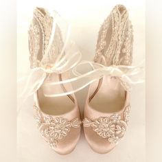 a pair of pink shoes with lace and pearls