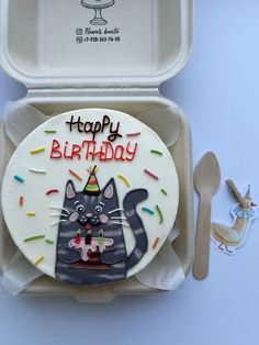 a birthday cake in a box with a cat on it