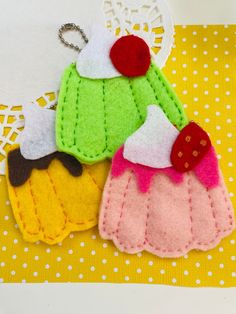 three felt cupcakes on a yellow and white polka dot tablecloth with a keychain