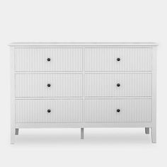 a white dresser with six drawers and two doors