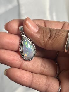 Embrace your best self with these magical Ethiopian Opal pendants. The brilliant southwest-styled setting and glowing teardrop stone make this exquisite pendant an excellent statement piece. Opals have been revered by many cultures for their unique mystical beauty and the belief that they protect against negative energy and soothe sadness. This lustrous pendant adds a touch of splendor to any outfit with its fiery hues. You won't be disappointed. Materials: .925 Sterling Silver, Ethiopian Opal A Handmade Teardrop Opal Jewelry, Mystical Teardrop Gemstone Jewelry, Opal Teardrop Jewelry With Natural Stones, Traditional Teardrop Large Pendant Jewelry, Mystical Teardrop Sterling Silver Jewelry, Traditional Gemstone Teardrop Pendant Jewelry, Traditional Teardrop Pendant Gemstone Jewelry, Traditional Teardrop Gemstone Pendant, Unique Teardrop Stone-set Jewelry