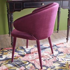 a purple chair sitting in front of a wooden desk