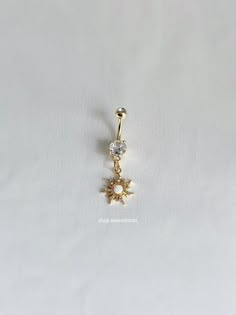 an image of a gold belly ring with flowers on the bottom and a diamond in the middle