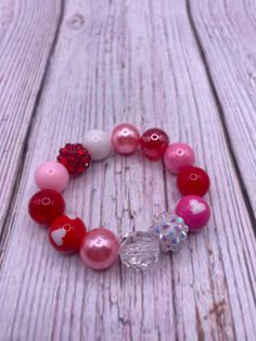 Bubblegum bead bracelet . Mix of 12mm bubble gum beads. Pattern varies with each order. Pink, white, red bubblegum beads,  heart charm.  Disclaimer-contains  small parts. Choking hazard. Not for children under 3. Cute Heart Beads Beaded Bracelets For Valentine's Day, Cute Heart Beaded Bracelets For Valentine's Day, Pink Charm Bracelet With Round Beads For Friendship, Pink Round Beads Charm Bracelet For Friendship, Pink Round Beads Jewelry For Valentine's Day, Cute Charm Bracelet For Birthday And Valentine's Day, Valentine's Day Birthday Beaded Bracelets With Round Beads, Personalized Red Beaded Bracelets For Birthday, Valentine's Day Round Beads Jewelry For Birthday