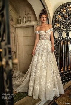 a woman standing in front of a gate wearing a wedding dress