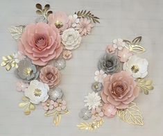 paper flowers and leaves are arranged on the wall