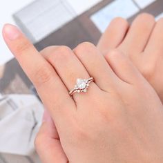 a woman's hand with a diamond ring on top of her finger and the other hand holding it