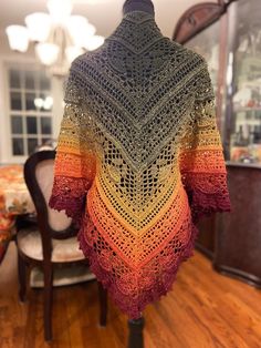 a crocheted shawl hanging from a table