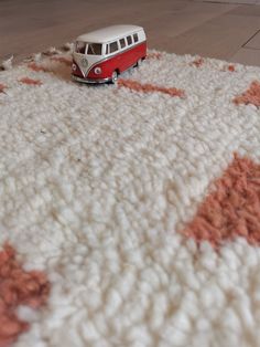 a red and white van is sitting on a rug