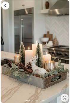 candles are sitting in a tray on the kitchen counter