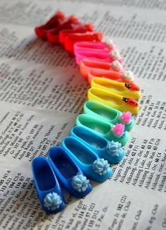 several pairs of colorful plastic shoes sitting on top of an open book