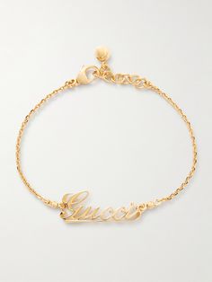 Gucci's bracelet is the perfect gift for a fan of the brand. It's been made in Italy from gold-tone metal and is centered with a script version of the house's moniker. Show it off with rolled cuffs or a sleeveless top. Luxury Gold-plated Jewelry With Gold-tone Logo, Yellow Gold Metal Jewelry With Gold-tone Logo, Luxury Gold-tone Jewelry With Logo Charm, Luxury Gold-tone Jewelry With Logo Lettering, Designer Gold-tone Metal Bracelets, Designer Gold-tone Metal Bracelet, Gold-tone Jewelry With Logo Charm For Formal Occasions, Formal Yellow Gold Bracelets With Gold-tone Logo, Luxury Gold-tone Bracelet With Logo Charm