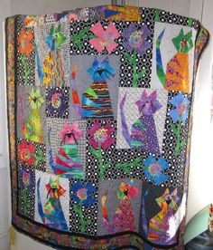 a colorful quilt hanging from the side of a wall