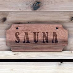 a wooden sign that reads sauna on it's side hanging from the wall