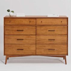 a wooden dresser with two vases sitting on it's top and bottom drawers