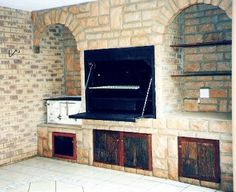 an empty room with brick walls and open ovens on the wall, in front of a white tiled floor