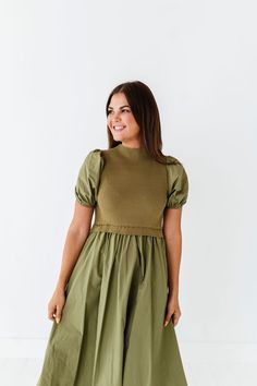 Features Mock neck Short puff sleeves with elastic Ribbed bodice Elastic waist Olive color Pockets 60% Cotton, 40% Polyester; Contrast: 52% Viscose, 26% Polyester, 22% Nylon Size + Fit Small 0-4, Medium 4-8, Large 8-12, X-Large 14-16, 1X 16-18, 2X 20-22, 3X 24-26 Kristin is 5'4", a size 1 and is wearing a Small Jaycie is 5'6" a size 18 and is wearing a 2X Runs true to size. Measurements taken while laying flat and then doubled. They do no account for stretch. Size Bra Band Length Small 34" 46" M Fitted Dress With Elastic Neckline And Puff Sleeves, Fitted Puff Sleeve Dress With Elastic Neckline, Fall Puff Sleeve Dress With Smocked Bodice, Green Puff Sleeve Dress For Fall, Fitted Puff Sleeve Dress With Smocked Back For Fall, Spring Dresses With Elastic Stretch Sleeves, Casual Stretch Dress With Puff Sleeves, Casual Puff Sleeve Fitted Dress, Spring Dresses With Elastic Shoulders And Stretch