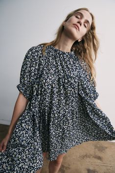 The Theo Dress is an oversized babydoll silhouette with elastic at the sleeve and neck. Floral print adds a pop of color and charm. Loose fit and flowy design in a lightweight seersucker fabric to add a subtle texture to the dress. 100% Japanese Cotton Seersucker Machine was delicate and hang to dry. Flowy Floral Print Dress With Puff Sleeves, Summer Flowy Puff Sleeve Dress With Gathered Neckline, Spring Voluminous Short Sleeve Puff Dress, Billowy Puff Sleeve Peasant Dress, Spring Smocked Dress With Billowy Gathered Sleeves, Casual Dress With Billowy Gathered Sleeves, Puff Sleeve Dress With Floral Print, Chic Billowy Floral Print Midi Dress, Flowy Puff Sleeve Dress With Smocked Bodice For Spring