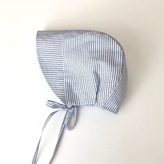 This unisex  bonnet is great for your little one for any occasion. This 100% cotton bonnet is made from a striped white/blue fabric. It has a brim to shade your baby from the sun. Machine wash or hand wash in cold water.  Smoke free, pet free home. If you have any questions, please feel free to ask. Cotton Curved Brim Bonnet For Beach, Curved Brim Cotton Bonnet For Beach, Curved Brim Cotton Bonnet For The Beach, White Cotton Bonnet For Spring, White Cotton Bonnet For The Beach, Cute Beach Bonnet One Size, Summer Striped Cotton Hat, Adjustable Cotton Bonnet For The Beach, White Cotton Beach Bonnet