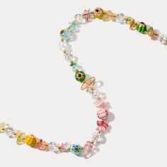 a multicolored beaded necklace with glass beads and charms on a white background