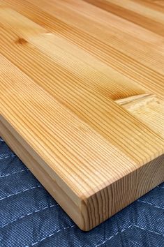 a wooden cutting board sitting on top of a blue cloth