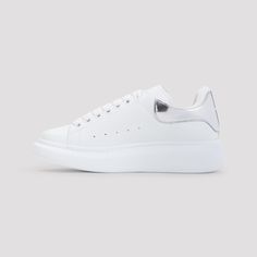 Alexander McQueen White Leather Sneakers. Pure white leather sneakers, round toe, top lace-up fastening, silver-tone printed logo on the tongue, perforated details on the upper, silver tone detail on the heel, back white logo on the heel, white rubber sole. Alexander Mcqueen White, Alexander Mcqueen Sneakers, Mcqueen Sneakers, White Leather Sneakers, Balenciaga Designer, Sneaker Wedge, Luxury Shop, Sneaker Shopping, Pure White