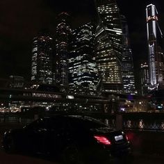 a car parked in front of a city at night