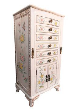 an ornate white cabinet with flowers painted on the front and drawers, decorated with gold hardware