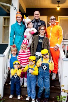 a group of people in costumes standing on the steps of a house with their children