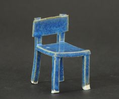 a miniature blue chair sitting on top of a table