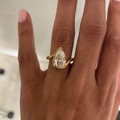 a woman's hand with a ring on it and a diamond in the middle