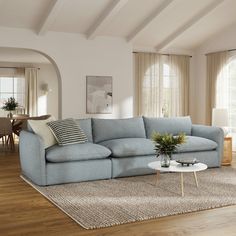 a living room filled with furniture and a large rug on top of a hard wood floor