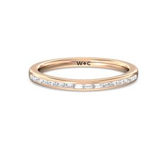 a rose gold wedding band with princess cut diamonds in the center and side stones at the bottom