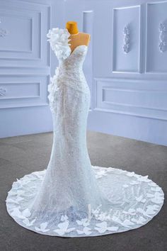 a wedding dress on display in a white room