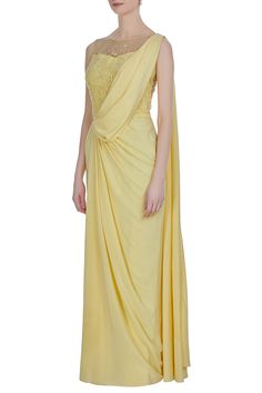 Awash in  mellow yellow hue, this crepe silk elegantly draped saree is enhanced with delicate hand embroidery at the bodice and back. The hand embroidery is created with katdana, crystals and sequins.
One piece saree with draped layer
Hand embroidery
Cutdana work with crystals and sequins
 - Aza Fashions Saree Style Gown, Draped Saree Gown, Pre Draped Saree, Cutdana Work, Drape Sarees, Online Shopping Sarees, Draped Saree, Lehenga Gown, Saree Gown