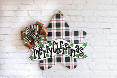 a wooden sign that says merry christmas hanging on a brick wall