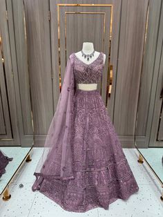 Our stunning Net Fabric Party Wear Lehenga in striking purple is perfect for making a bold statement at any special occasion, featuring intricate embroidery work in gold and silver threads. Elegant Semi-stitched Purple Sets, Elegant Semi-stitched Lavender Set, Lavender Sets With Intricate Embroidery For Festive Occasions, Festive Lavender Sets With Intricate Embroidery, Purple Embellished Sharara For Eid, Embellished Purple Sharara For Eid, Fitted Lavender Embroidered Sets, Embroidered Fitted Lavender Sets, Purple Sharara With Cutdana And Traditional Drape