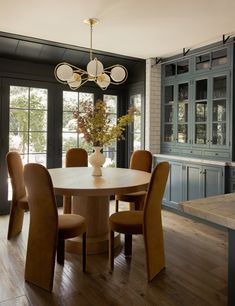 the dining room table is surrounded by brown chairs