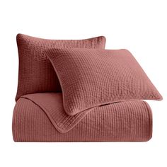 two pink pillows sitting next to each other on top of a white surface and one is folded