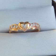 This is a beautiful 18ct solid warm yellow gold diamond ring . The center heart shaped diamond gemstone measures approx 2.0mm.  The 6 x side of diamonds measure approx 1.5mm each. These diamonds are quality, clear and have fantastic fire. The heart is not flat but rounded and modern. The center heart shaped diamond has a more subdued twinkle because round cut diamonds have the most brilliance. A sweet quality ring, it is in excellent shiny condition. The ring has no hallmark, but tested guaranteed 18k gold. Weight: 3.2 grams Size (AU)  L  (US ) 5.75 Heart Cut Diamond Ring With Rose Cut For Promise, Gold Diamond Heart Ring For Valentine's Day, Heart-shaped Yellow Gold Diamond Ring, 14k Heart Cut Diamond Ring For Valentine's Day, Heart Cut Ring With Rose Cut Diamonds, Heirloom Diamond Ring With Heart Cut, Heirloom Diamond Heart Cut Ring, Heirloom Heart Cut Diamond Ring, Gold Diamond Cut Heart Ring