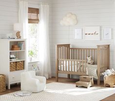 a baby's room with white walls and wooden furniture