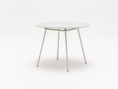 a white table with metal legs and a glass top on an isolated surface in front of a plain background