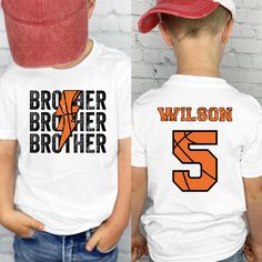 This cute Custom basketball brother Shirt is the cutest shirt to support his brother during his basketball season games! This shirt Features brother's baseball name and number on the back of his shirt, with Brother on the front with the basketball look. This Little kid brother basketball game shirt will sure to make his brother smile in support of his Big Brother Basketball Shirt. These Toddler boy basketball Sibling Tee comes in a variety of sizes and colors to show off his Basketball Bro Shirt to his brother and the crowd! ║ ABOUT OUR TODDLER, YOUTH AND INFANT SHIRTS ║ ◆ Sizes offered: See the Sizes we offer per the drop down menu ◆ Material: 100% Soft Cotton for the T-shirts and bodysuits ◆ Style: Unisex gender neutral clothing ◆ Care: Machine wash cold, inside out with like colors. Tum Basketball Brother Shirt, Sports Brother Shirt, Collegiate White Tops With Number Print, Collegiate White Top With Number Print, White Letter Print Basketball T-shirt, White Basketball T-shirt With Letter Print, White Letter Print T-shirt For Basketball, White T-shirt With Letter Print For Basketball, Personalized Game Day Tops With Team Spirit