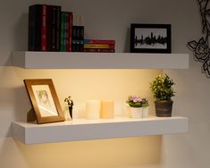 a shelf that has some candles and pictures on it