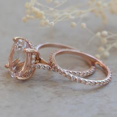 two wedding rings with an oval cut diamond