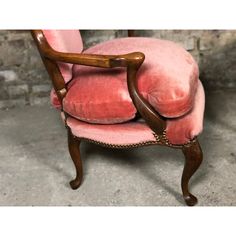 a pink chair sitting on top of a cement floor